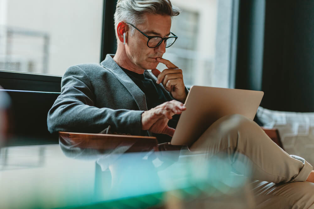 Businessman looking at laptop and thinking - hire intelligence